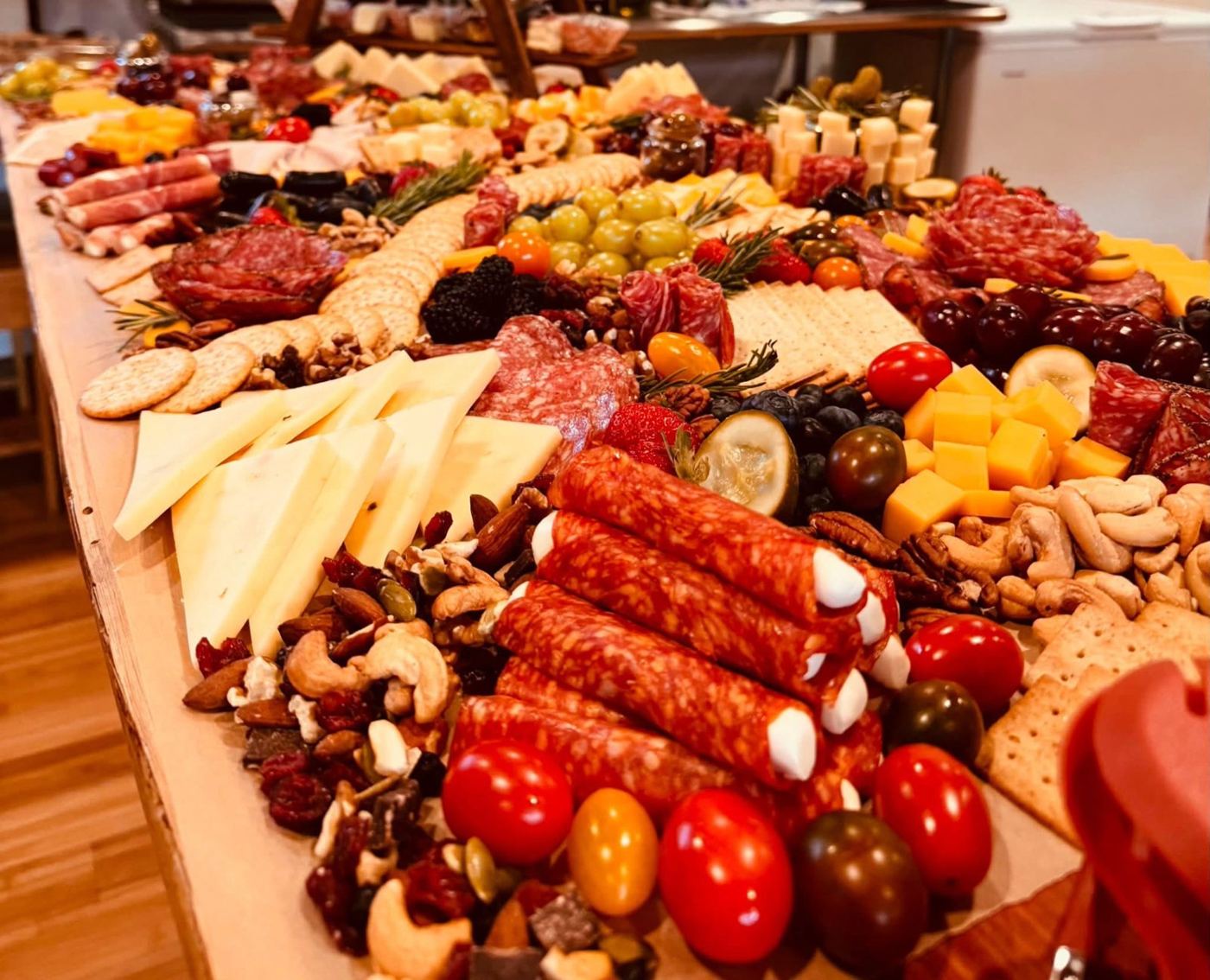 A long grazing table of cheeses, meats, fruit, nuts and crackers