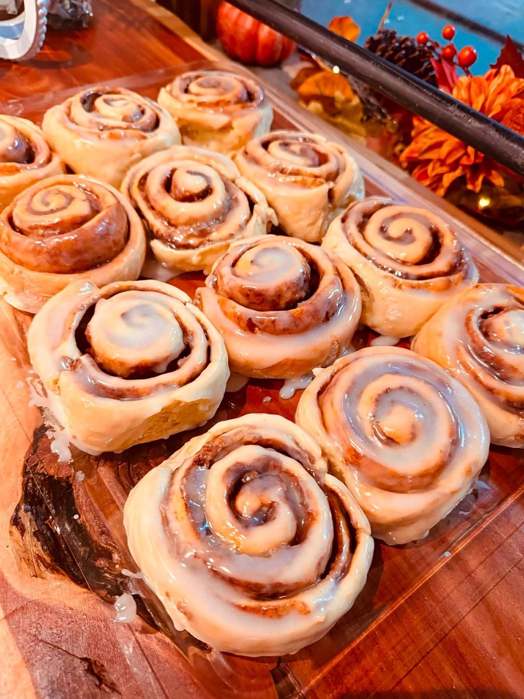 A tray of fresh glazed cinnamon rolls on a cedar counter at FrosTY Acres
