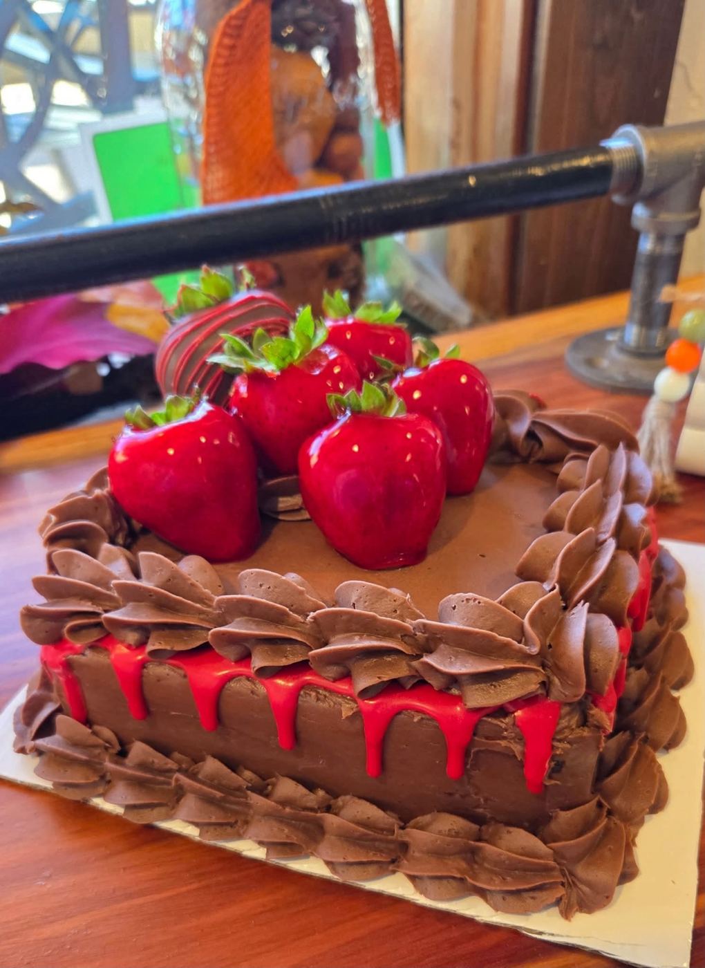 A heart-shaped chocolate cake crowned with chocolate-dipped strawberries